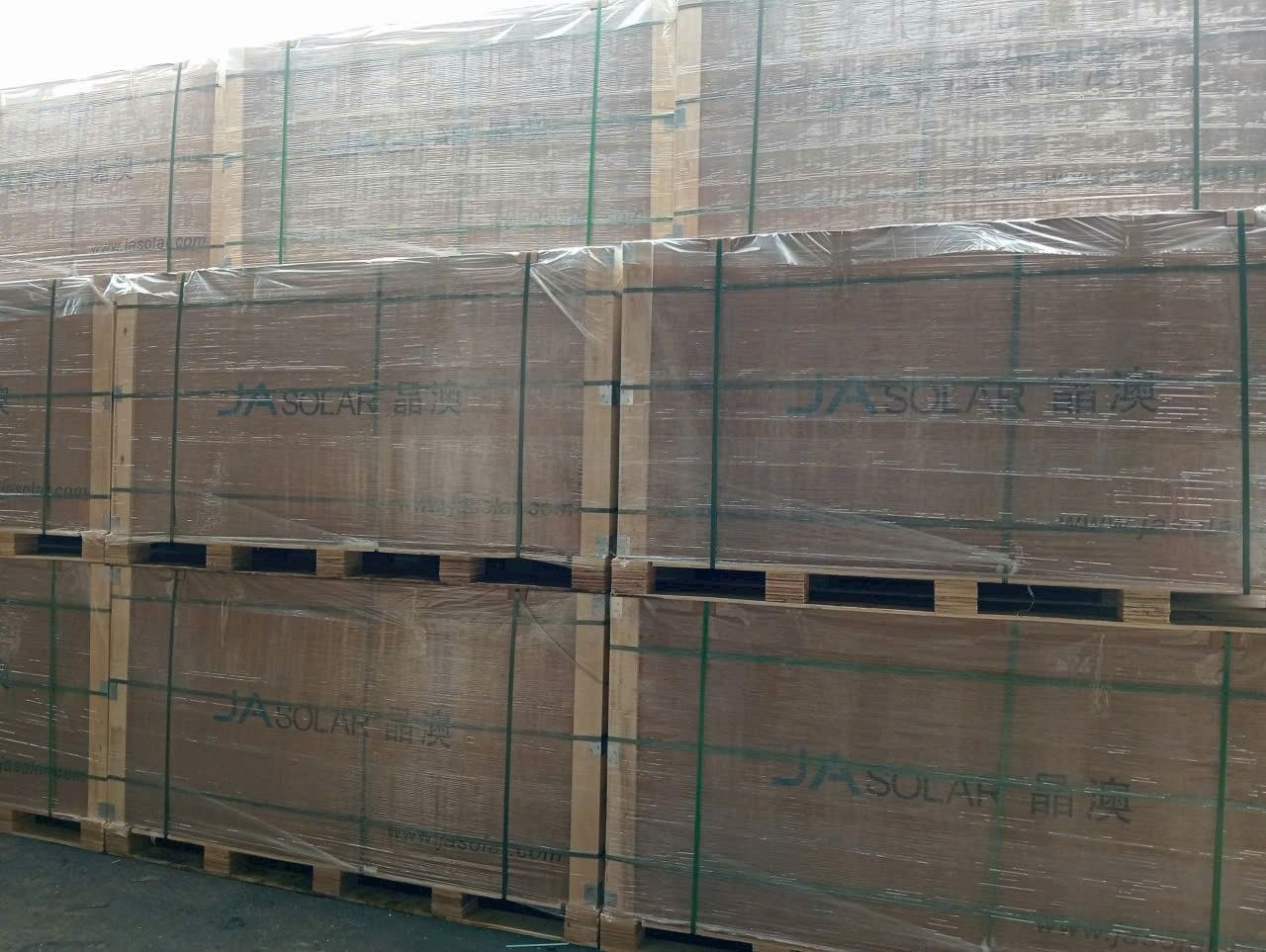 Kho hàng JA Solar thực tế — pallet tấm pin được xếp gọn gàng, sẵn sàng giao dự án